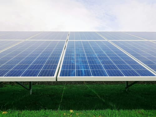 Rows of solar panels in a green field
