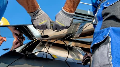 Technician wiring solar panels during installation